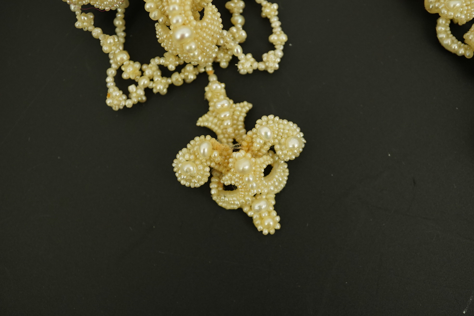 A cased 19th century seed pearl cluster mounted mother of pearl demi parure